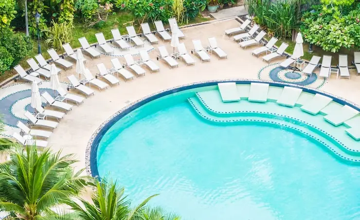 Round pool with sun loungers and tiered entry by Heavenly Outdoor in Fulshear, TX