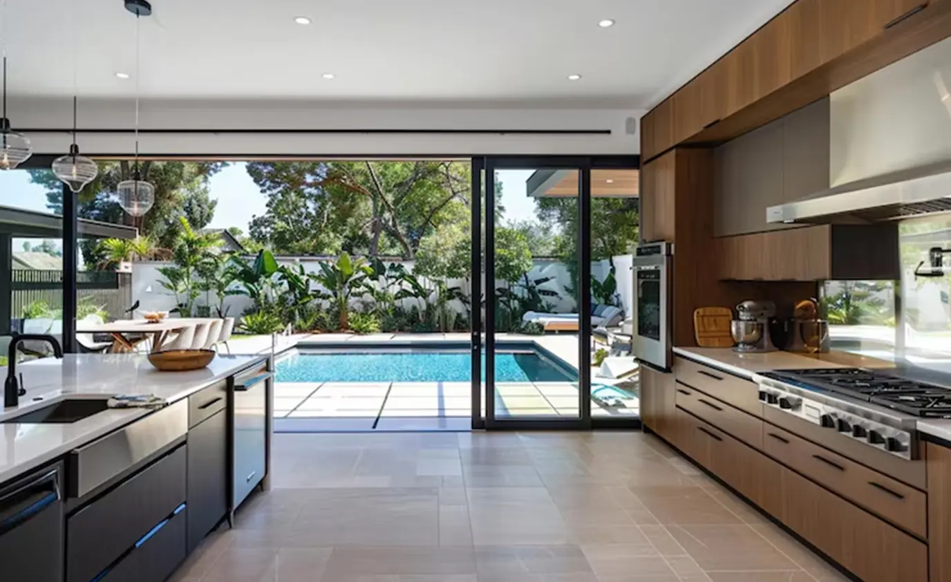Modern outdoor kitchen opening onto a pool designed by Heavenly Outdoor in Galveston, TX