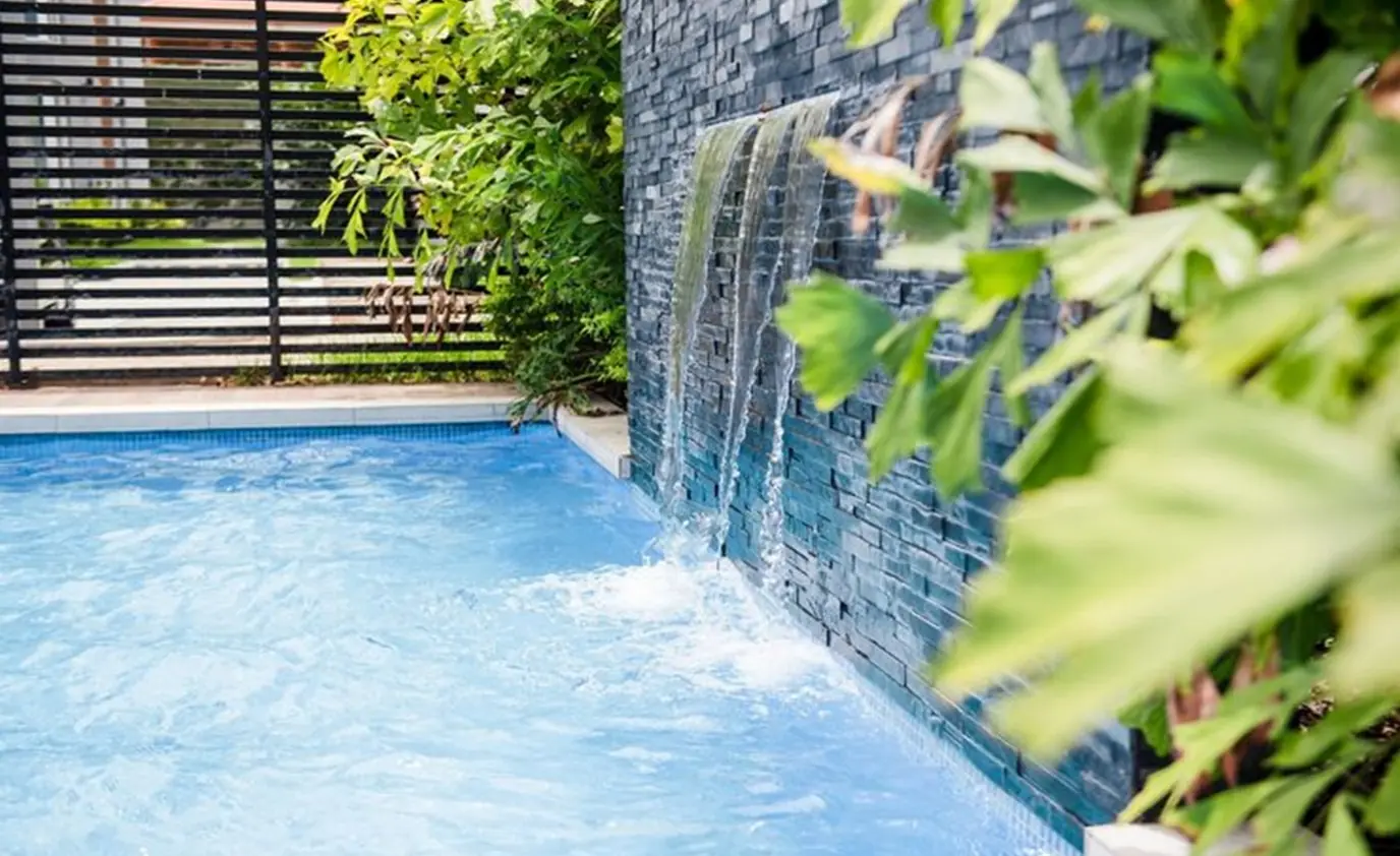 Pool water feature with cascading waterfall wall installed by Heavenly Outdoor in Galveston, TX