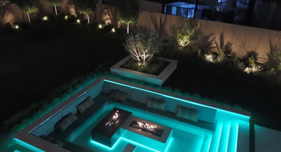 Backyard with a waterfall, fire feature and gardens