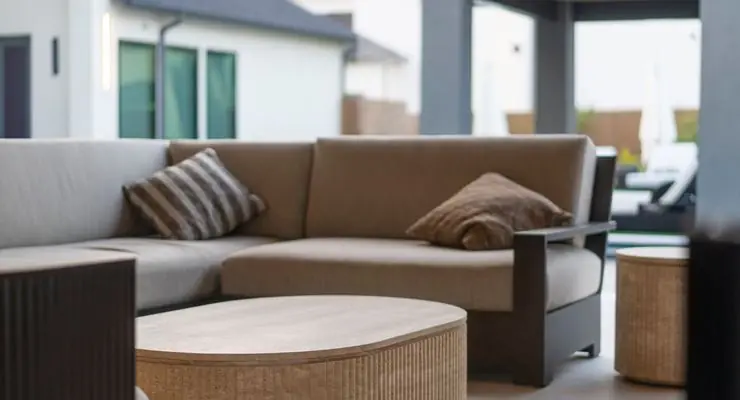 Built-in outdoor sofa with striped cushions and a wicker coffee table